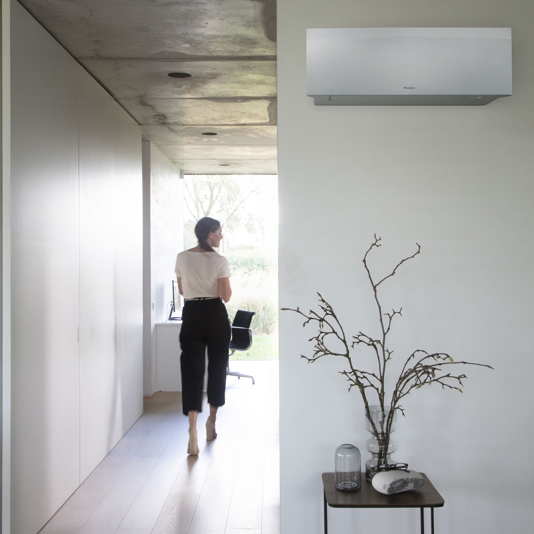 Pregnant mother on couch with Daikin Emura on wall