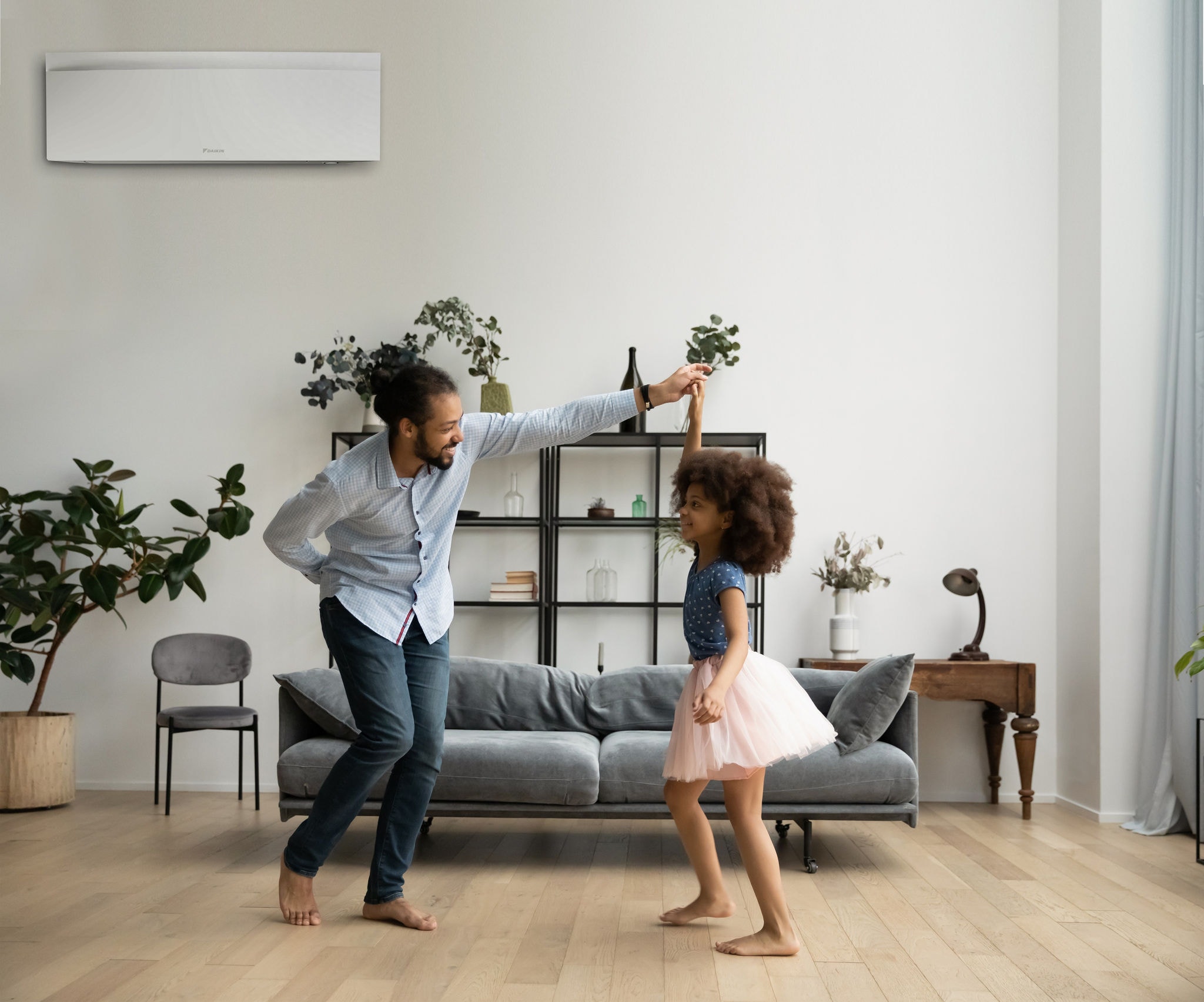 An air-to-air heat pump air conditioning the home of a mother and two daughters having breakfast